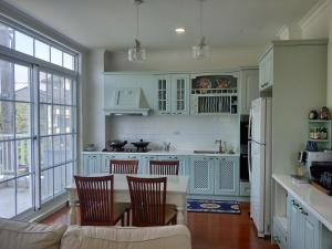 una cucina con mobili bianchi, tavolo e sedie di 葛萊絲鄉村小屋 Glass Country loft a Hsinchu