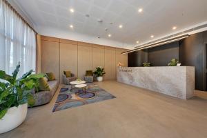 an office lobby with a counter and a table at Littomore Suites Kingswood in Penrith