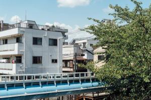a white building with a bridge over a river at Bird Place log Tokyo #KS1 in Tokyo