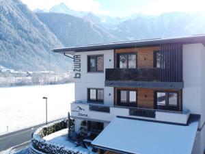 dom ze śniegiem na ziemi obok góry w obiekcie Apartment in Mayrhofen near Ski Lifts w Mayrhofen