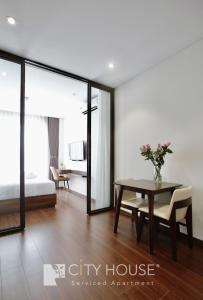 a dining room with a table and a bedroom at Cityhouse Villea in Ho Chi Minh City