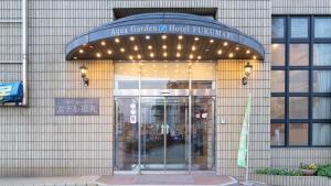 a building with an entrance to a hospital with lights at Aqua Garden Hotel Fukumaru in Kagoshima