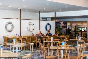 two people sitting at tables in a restaurant at Bribie Island Hotel in Bellara