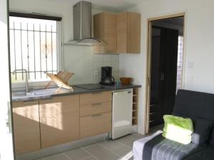 eine Küche mit einer Theke und einer Couch in einem Zimmer in der Unterkunft Maison 2 pièces avec WiFi, Dolus-d'Oléron - FR-1-246A-350 in Dolus d'Oléron