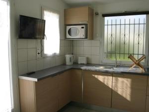 eine Küche mit Spüle und Mikrowelle in der Unterkunft Maison 2 pièces avec WiFi, Dolus-d'Oléron - FR-1-246A-350 in Dolus d'Oléron