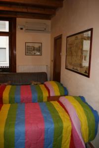 1 dormitorio con 2 camas y una manta colorida en JLL Room, en Foggia