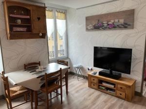 ein Wohnzimmer mit einem Esstisch und einem Flachbild-TV in der Unterkunft Appartement Mont-Dore, 3 pièces, 4 personnes - FR-1-415-99 in Le Mont-Dore