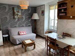 ein kleines Wohnzimmer mit einem Bett und einem Tisch in der Unterkunft Appartement Mont-Dore, 3 pièces, 4 personnes - FR-1-415-99 in Le Mont-Dore