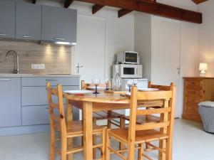 een keuken met een houten tafel met stoelen en een magnetron bij Appart 2 pièces proche plage Dolus-d'Oléron - FR-1-246A-1 in Dolus d'Oléron