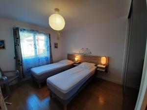 2 camas en una habitación con lámpara y ventana en Appartement Soorts-Hossegor, 2 pièces, 4 personnes - FR-1-239-583, en Soorts-Hossegor