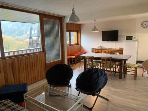 a living room with a table and a dining room at Appartement Mont-Dore, 3 pièces, 6 personnes - FR-1-415-100 in Le Mont-Dore