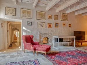 ein Wohnzimmer mit einem roten Stuhl und einem Kamin in der Unterkunft Maison Saint-Rémy-de-Provence, 8 pièces, 12 personnes - FR-1-599-4 in Saint-Rémy-de-Provence