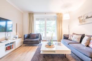 a living room with a couch and a tv at Haus Ameland, App 3 in Wenningstedt