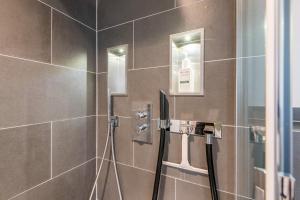 a bathroom with a shower with brown tiles at Haus Ameland, App 3 in Wenningstedt +28 photos
