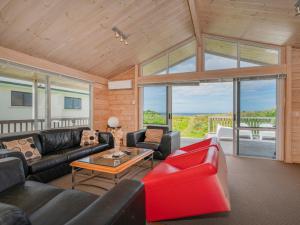 - un salon avec un canapé et une table dans l'établissement Ocean Beach Beauty - Tairua Holiday Home, à Tairua