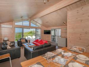 - un salon avec des plafonds en bois, une table et des chaises dans l'établissement Ocean Beach Beauty - Tairua Holiday Home, à Tairua