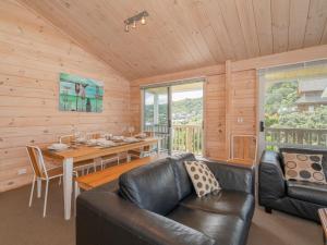 - un salon avec un canapé en cuir et une table dans l'établissement Ocean Beach Beauty - Tairua Holiday Home, à Tairua