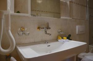 un bagno con un lavandino bianco e uno specchio di Hotel Eigerblick a Grindelwald