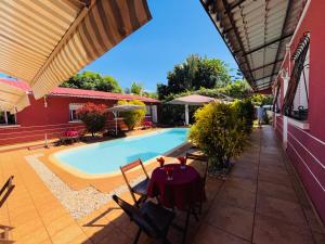 a patio with a table and a swimming pool at Régina Lodge Diégo Suarez Madagascar in Antsiranana