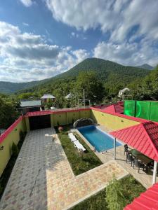 a house with a swimming pool and a mountain at Guest house in Qabala in Gabala