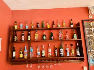 a wall with shelves filled with bottles of alcohol at Régina Lodge Diégo Suarez Madagascar in Diego Suarez