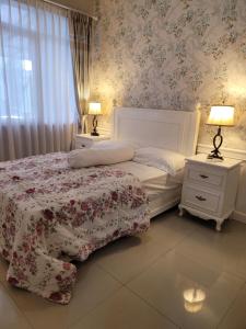 - une chambre avec un lit et 2 tables de nuit avec des lampes dans l'établissement Gemintang House At Arcadia Residence, à Cireungit