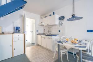 a kitchen and dining room with a table and chairs at null Haus Frisia, Whg 407 in Sankt Peter-Ording