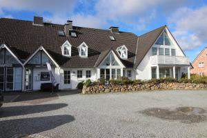 a large white house with a black roof at null Haus Frisia, Whg 407 in Sankt Peter-Ording