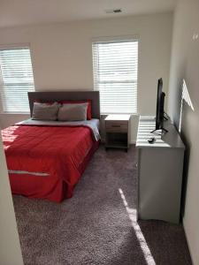 a bedroom with a bed and a desk with a television at SC 3745 New Townhouse Ft Jackson & USC in Columbia