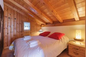 um quarto com uma cama branca e almofadas vermelhas em Village des Oursons C - Happy Rentals em Chamonix-Mont-Blanc