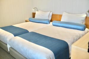 two beds sitting next to each other in a room at Naha Tokyu REI Hotel in Naha