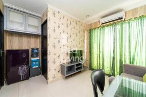 een woonkamer met groene gordijnen en een tv bij RedLiving Apartemen Sentra Timur Residence - Myroom id Tower Green in Jakarta