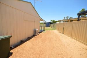 a dirt road next to a fence next to a building at Surf Caster - Kalbarri, WA in Kalbarri
