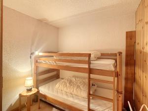 Zimmer mit Etagenbett, 2 Etagenbetten und einer Lampe in der Unterkunft Appartement Combloux, 3 pièces, 5 personnes - FR-1-560-33 in Combloux