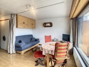 ein Wohnzimmer mit einem Tisch und einem blauen Sofa in der Unterkunft Studio Combloux, 1 pièce, 2 personnes - FR-1-560-54 in Combloux