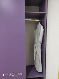 um armário com uma prateleira com toalhas brancas em City Hotel Shymkent em Shymkent