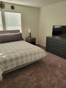 um quarto com uma cama, uma cómoda e uma televisão em SC 3755 New 2 bedroom Townhouse Ft Jackson & USC em Columbia