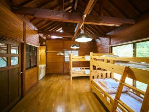 a room with two bunk beds in a cabin at Lodge Kiyokawa in Bungoono