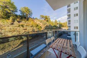 a balcony with a wooden table and chairs at Modern Flat with Shared Pool and Balcony in Alanya in Avsallar