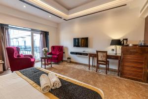una camera d'albergo con letto, scrivania e sedie di Alvorada Resort-3 Star Resort In Baga ad Arpora