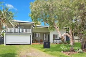 a house with a white garage and a tree at 20 Mackay St Dicky Beach QLD in Caloundra