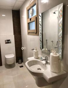 a bathroom with a sink and a toilet and a mirror at Weekdays Hotel in Muscat