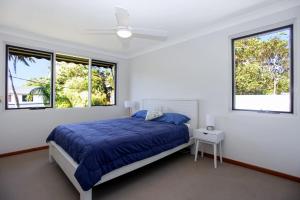 - une chambre avec un lit bleu et 2 fenêtres dans l'établissement Sirocco, à Hawks Nest