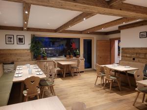 a restaurant with tables and chairs in a room at Pension Schnaitl in Maria Alm am Steinernen Meer