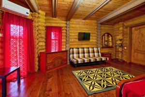 sala de estar con cortinas rojas, sofá y TV en Hobza Hutor, en Loo