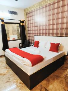 鲁德拉普尔Hotel kingsman的卧室里有一张大床，配有红色枕头