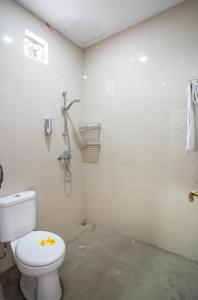 y baño con aseo y ducha. en Lavanda guesthouse/homestay, en Jimbaran