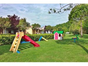 a yard with childrens play equipment in the grass at Casabianca Resort Villas in Lignano Sabbiadoro