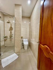 a bathroom with a glass shower and a toilet at Royal Hotel 2 in Bạc Liêu