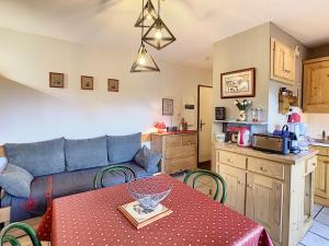 ein Wohnzimmer mit einem Sofa und einem Tisch sowie eine Küche in der Unterkunft Appartement Combloux, 2 pièces, 4 personnes - FR-1-560-20 in Combloux